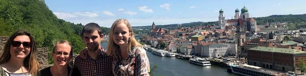 Four NWU students standing in front of a European river and city.